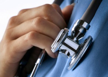 A doctor wearing blue scrubs with a stethoscope