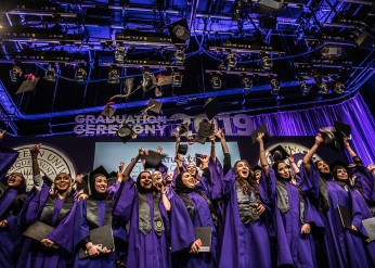 Graduating students tossing their graduation caps