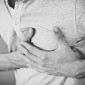 A man holds his hands against his heart in pain.