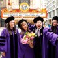 Four graduating students in front of the Chicago Theatre