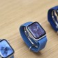 Three smart watches sit together on a deak