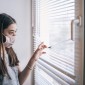 teen wearing mask at window