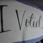 A voting sign is held by a student in Northwestern's Voter Van. 