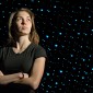 Kimberly Clinch standing in front of a space background.