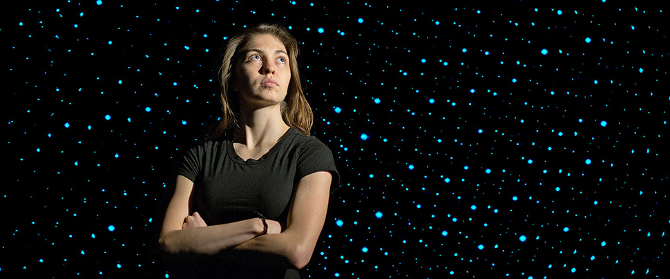 Kimberly Clinch standing in front of a space background.