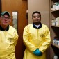 Jim Williams (left) and Hemang Rana of Clean Harbors next to chemical bottles at Chute Middle School in Evanston. Clean Harbors partnered with Northwestern's Office for Research Safety safely dispose of excess chemical products Dec. 28-29 from six local schools.