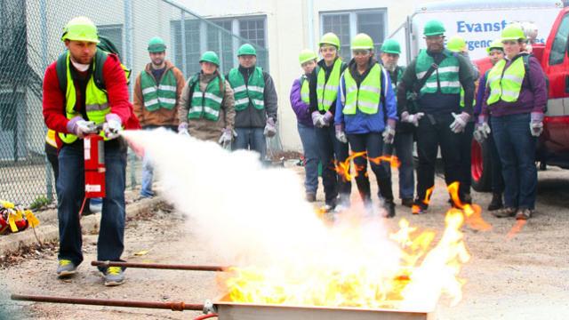 A man puts out a fire with a fire extinguisher