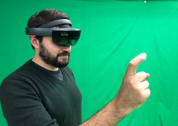 Man wearing HoloLens headset in front of green screen