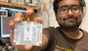 Co-corresponding author Anirudh Ramesh holds a circuit board containing the new chip.