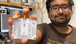 Co-corresponding author Anirudh Ramesh holds a circuit board containing the new chip.