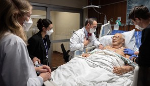 Dr. Brian Garibaldi meets with a patient as students and fellow physicians watch and learn. 