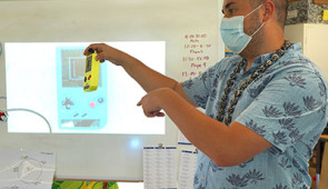 Hester shows the class a Battery-free GameBoy, built in his lab.