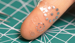 Three variations of the sticker displayed on a finger tip