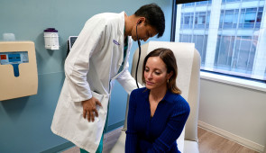 Dr. Ankit Bharat listens to patient Danielle Hoeg's lungs.
