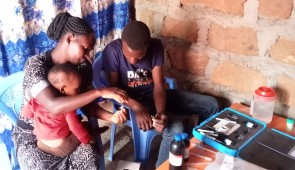 A family in rural Kenya field test the point-of-use fluoride biosensors. Photo by Janet Barsolai. 