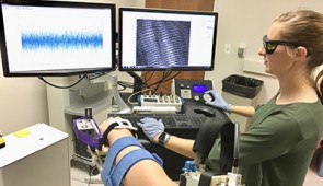 Ph.D. candidate Amy Adkins uses microendoscopy to image sarcomeres (shown on the upper right screen) inside a patient's arm muscle.