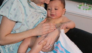 A baby wears early iterations of the Rogers team’s soft, thin, flexible devices. The wireless, wearable devices replace the tangle of wire-based sensors that currently monitor newborns’ vital signs and pose a barrier to skin-to-skin contact and physical bonding between parents and their children.