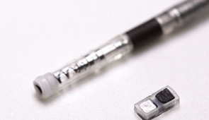 Close-up of the new tiny pacemaker next to the lead of a traditional pacemaker.