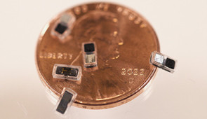 Pacemakers sitting on a penny for scale.