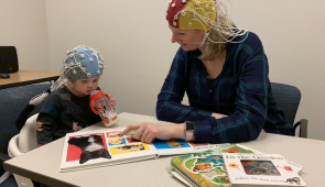 toddler with parent wearing eeg cap