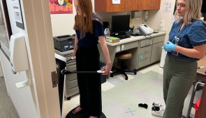 A study participant stands on the InBody machine to take measurements.