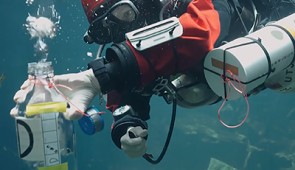 Advanced buoyancy skills are required for taking sterile 1-liter water samples. A diver uses an air hose to completely void the sterile bottle, which is then inverted and flooded with the sample water, with the specific depth recorded from wrist mounted depth gauges. 