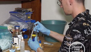 Matt Selensky processes water samples in the lab. He uses a vacuum system powered by a bicycle pump to draw the water through sterile filters, collecting the micro-organisms on the filter, which are preserved for later gene sequencing.