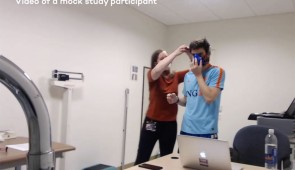 A researcher puts equipment on a mock study participant. This includes putting on a metabolic cart — a mask that measures the volume of oxygen the wearer inhales and the volume of carbon dioxide the wearer exhales to calculate their energy burn (in kilocalories/kCals) and resting metabolic rate. 