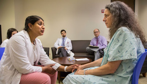 A medical student enrolled in Northwestern University Feinberg School of Medicine's simulation-based mastery learning course practices breaking bad news to a trained actor while a faculty member and fellow medical students observe. The course train physicians to deliver bad news to patients in a clear and compassionate way.