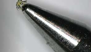 Tiny robotic crab sits on the tip of a ball-point pen.
