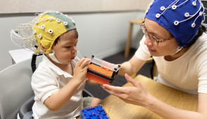 child with parent wearing eeg cap