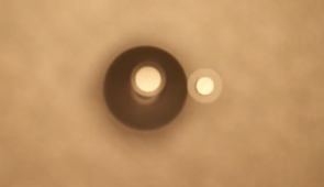 Periodic beating in a heterogeneous (different charges) system of two particles