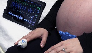 Pregnant mother's and baby's vital signs displayed on a mobile device.