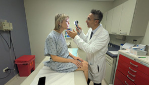 Dr. Pedram Gerami examines the skin of patient and melanoma survivor Heidi Tarr