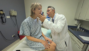 Dr. Pedram Gerami examines the skin of patient and melanoma survivor Heidi Tarr