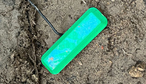 The device's 3D-printed cap sticks out of the ground