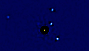 Four faint exoplanets orbit star HR8799, which is represented by a star-shaped icon in the center. (The star itself was removed from the video because its glare is so intense that it blocks out the surrounding planets.)