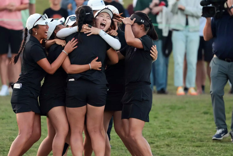 The Northwestern women's golf team celebrates with a group hug after winning the championship