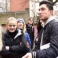 Students stand and talk in a group outside.