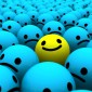 The illustration shows a yellow smiley face ball among a crowd of blue frown face balls.
