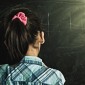 A girl stands at a chalkboard