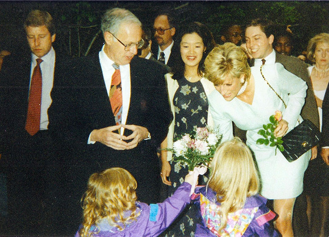 Two young girls hand flowers to Princess Diana
