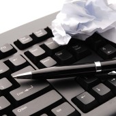 Keyboard with crumpled paper and pen