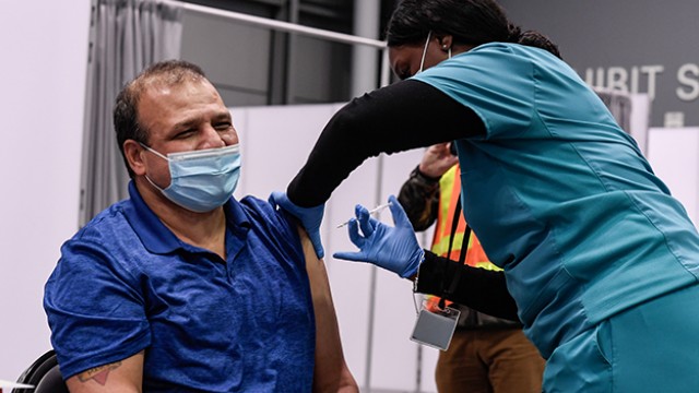 A frontline worker receives a COVID-19 vaccine. A frontline worker receives a COVID-19 vaccine.