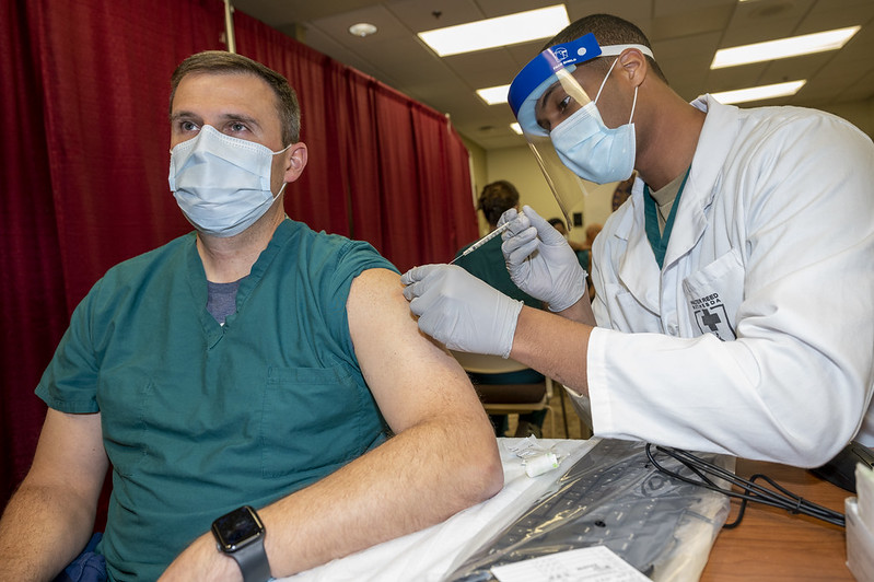 A doctor at Walter Reed National Military Medical Center, receives a COVID-19 vaccination. Department of Defense photo by Lisa Ferdinando courtesy of Flickr.