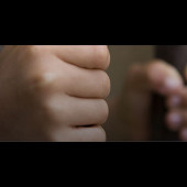 youth in detention with hands on bars
