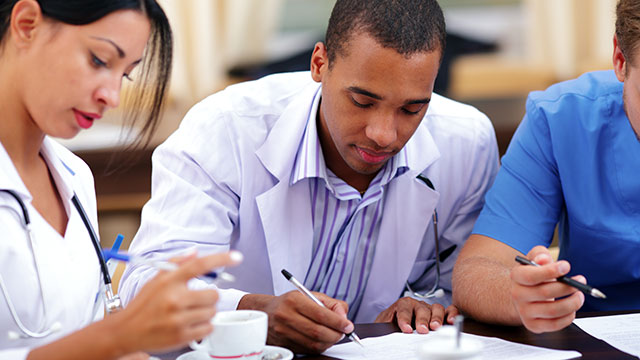 Medical students completing paperwork Medical students