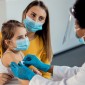 Mother holding a young child during doctor visit