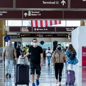 Masked travelers walking through an airport