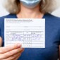 Health worker holding vaccination card